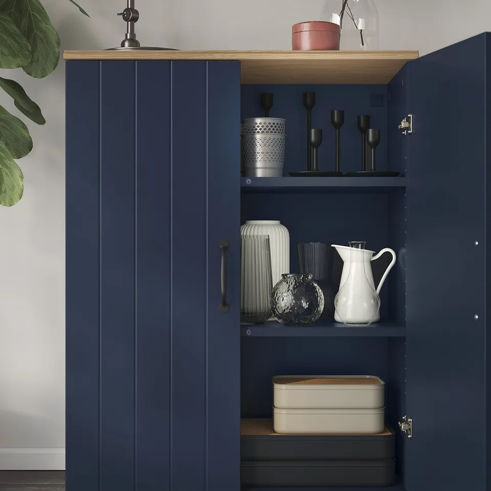 Navy cabinet with oak top, displaying vases and candles, with adjustable shelves for versatile storage.