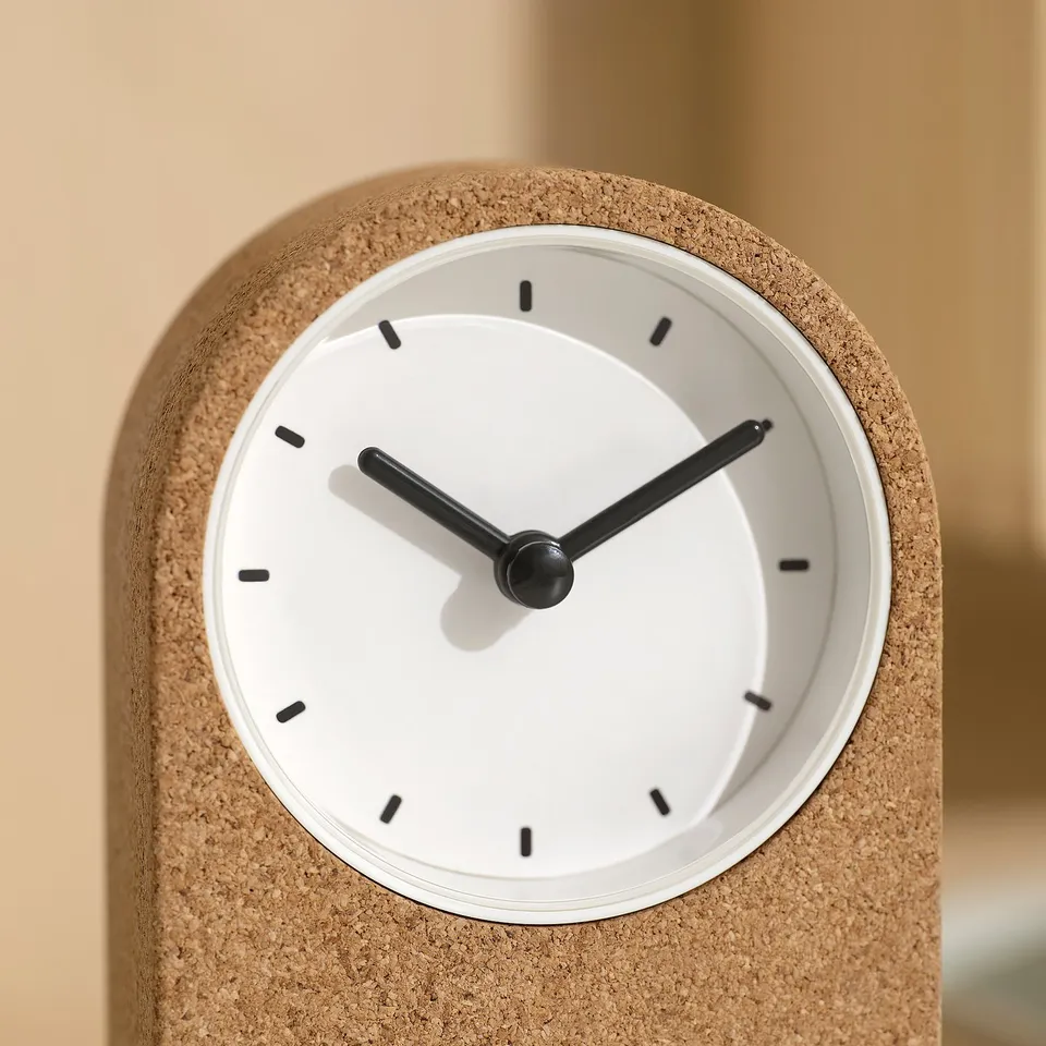 Modern round clock with cork frame, white face, black hands, and no ticking sound.