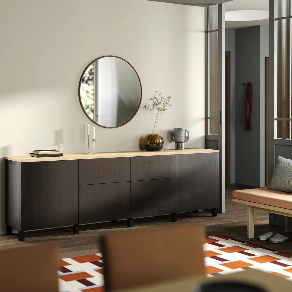 Large modern wooden sideboard with cabinets, a round mirror above, decor items, and an entryway bench.