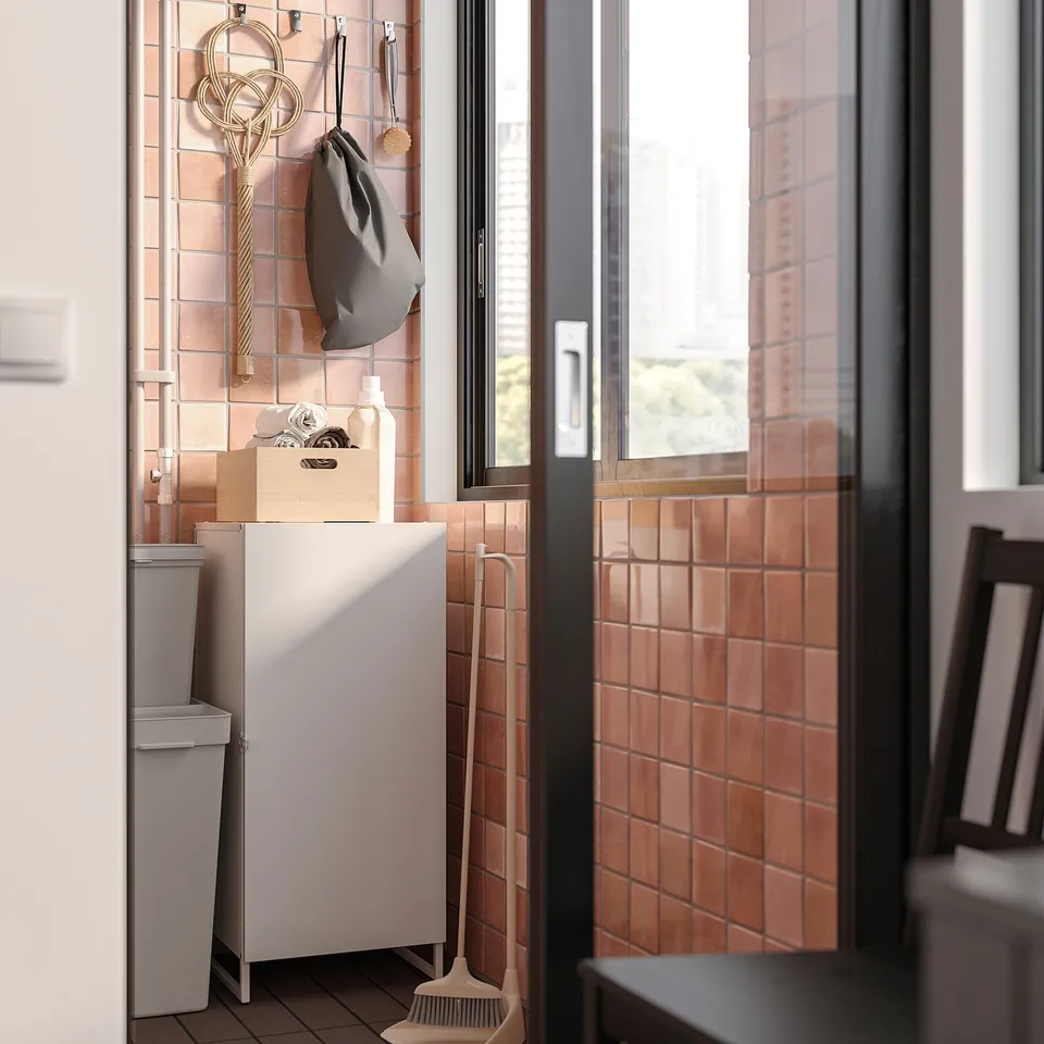 Small organised space with JOSTEIN white cabinet, tiled walls, outdoor view.