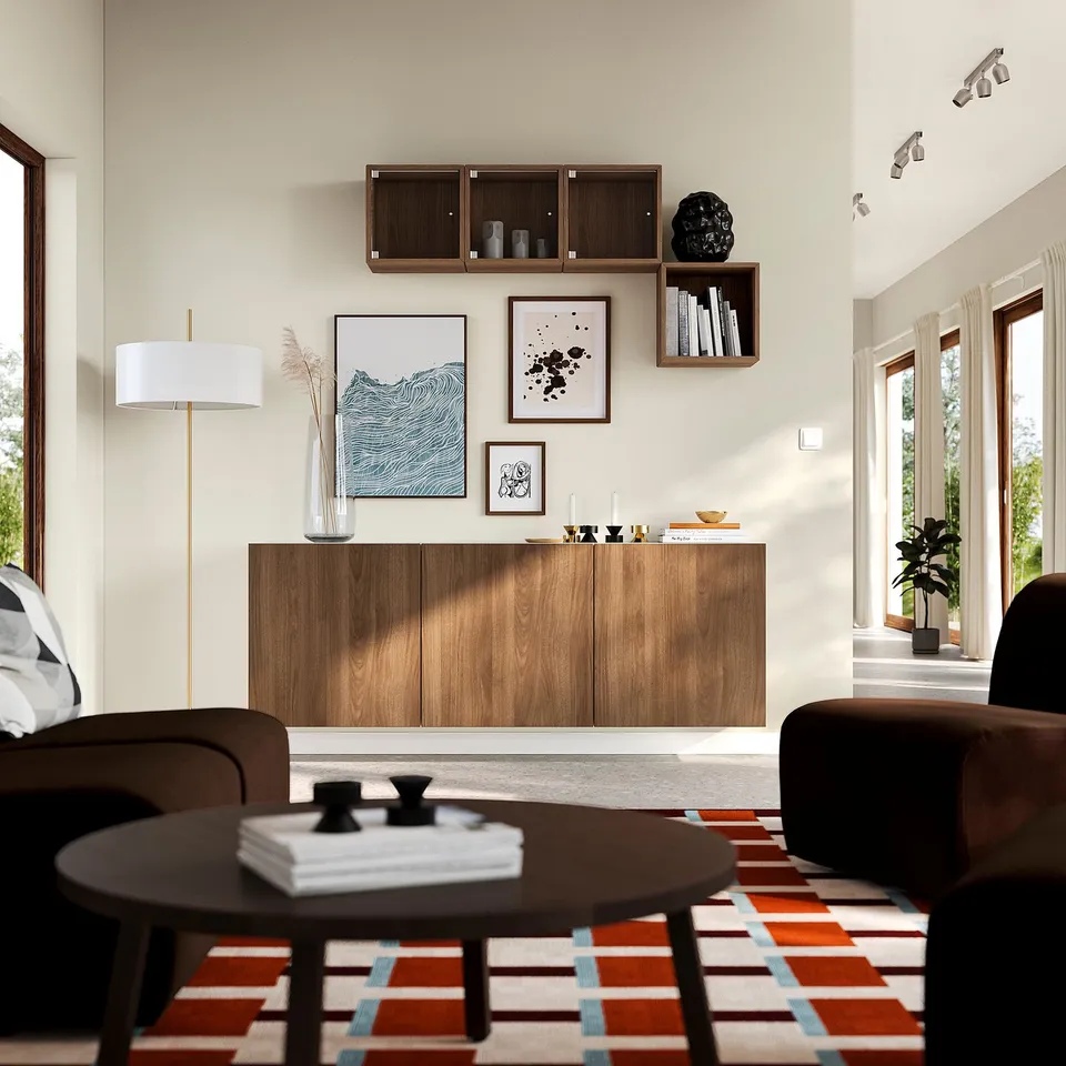 Modern living space with BESTÅ wooden storage unit against wall, featuring adjustable shelves, decorative art, and cosy seating.