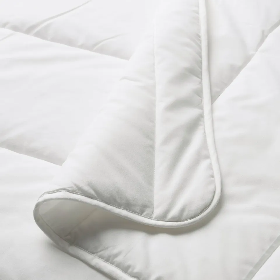 Close-up of a pristine, fluffy duvet with neat stitching, showcasing its soft texture and high-quality craftsmanship.