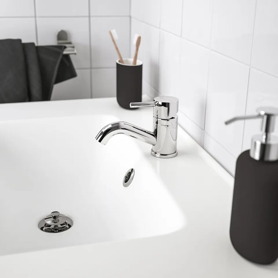 Modern bathroom with chrome PILKÅN tap, black soap dispenser, and toothbrush holder.