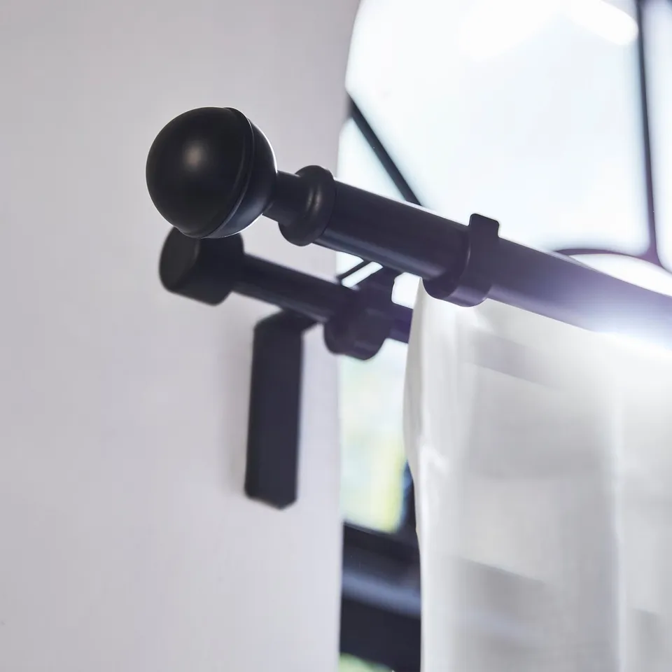 Black ALVARSTÅNDS finial on curtain rod, small spherical design.