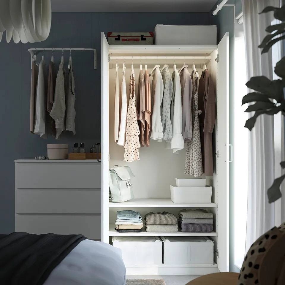 Organised closet with hangers, folded clothes, boxes, and adjustable shelves.
