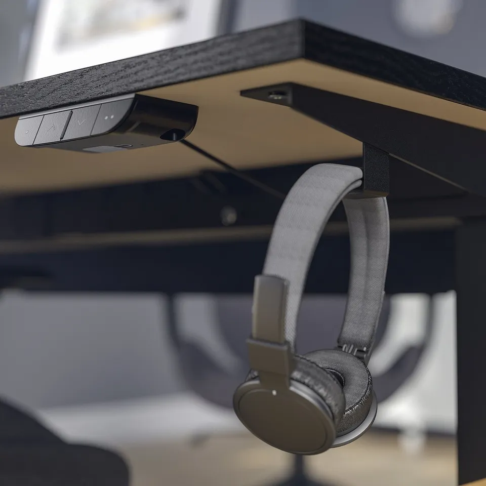 Headphones hang on desk hook, control panel above.