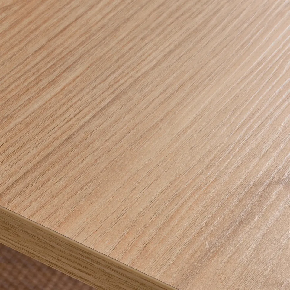 Close-up of TROTTEN desk surface: smooth, light wood grain texture, high-quality finish.