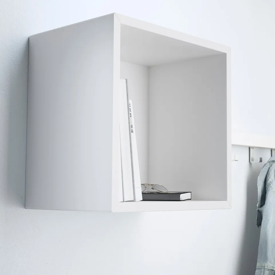 A minimalist floating shelf, part of the EKET series, displaying a few items.