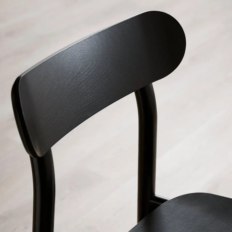 Modern black chair backrest and armrests, sleek design with smooth curved edges.