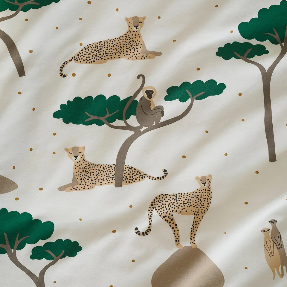 Illustrated savannah scene with cheetahs, monkeys, and trees on duvet cover.