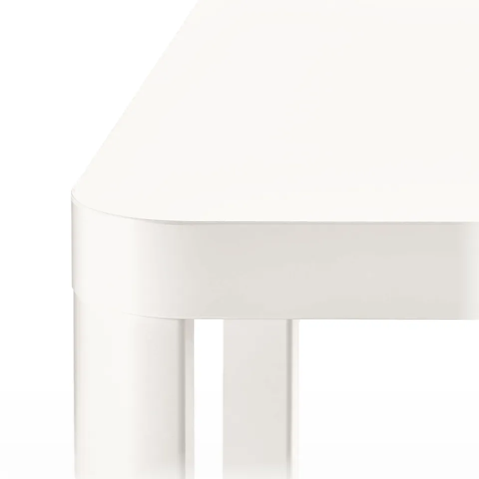 Close-up of white table edge; sleek, curved design; smooth, clear finish.