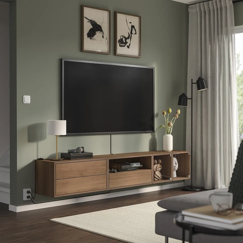 Modern living room with tv on EKET unit, decor, art, green walls, rug, curtains.