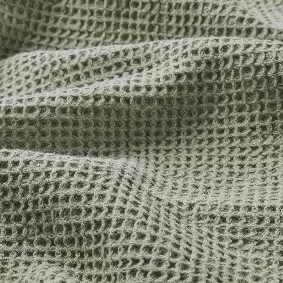 Close-up of soft, greenish VALLASÅN towel, showcasing its woven texture and lightweight, absorbent material.