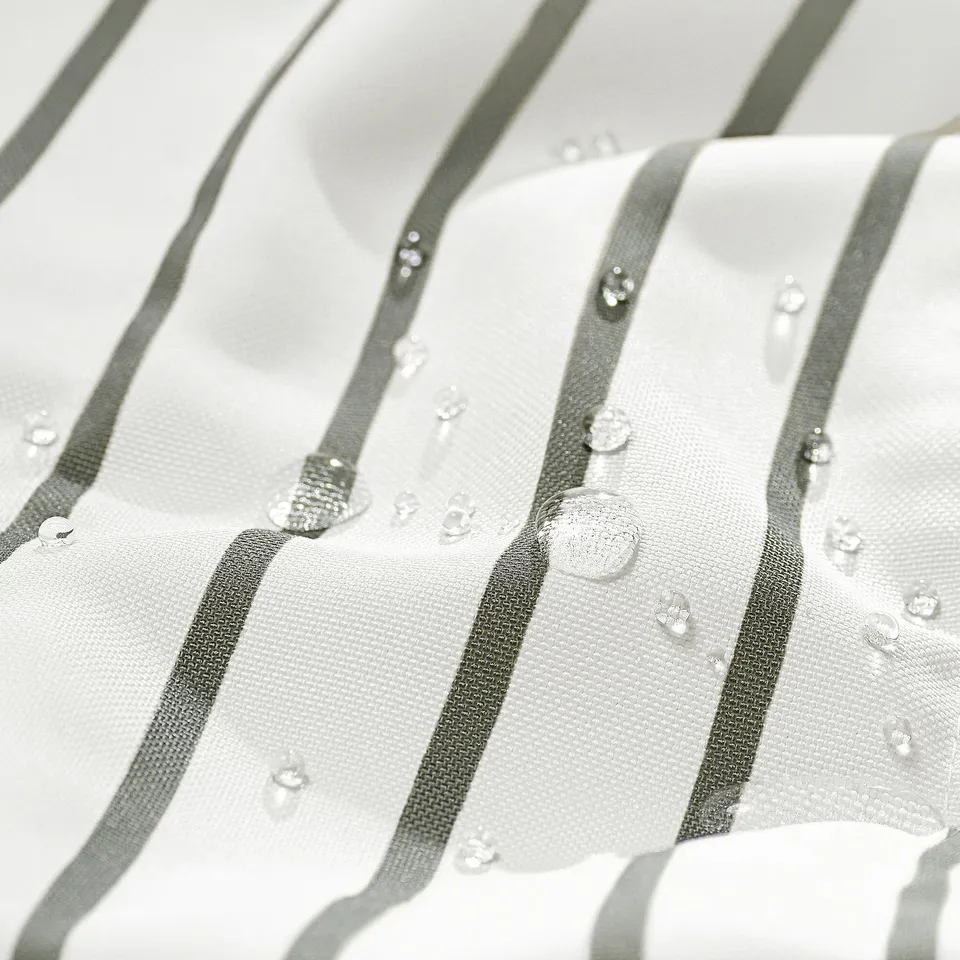 Close-up of UTSÅDD pet blanket, showcasing water repellent, striped fabric with droplets highlighting quality and durability.