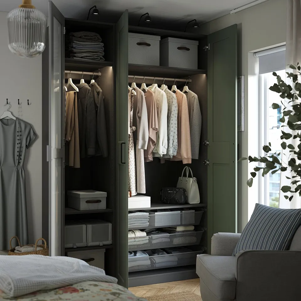Well-organized closet with clothes, shelves, and containers, featuring built-in lighting and a hanging rod.