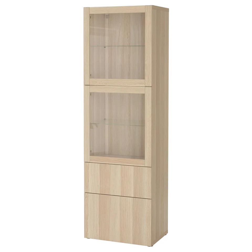 A tall, light oak BESTÅ cabinet with glass doors. Shelves for display and storage.