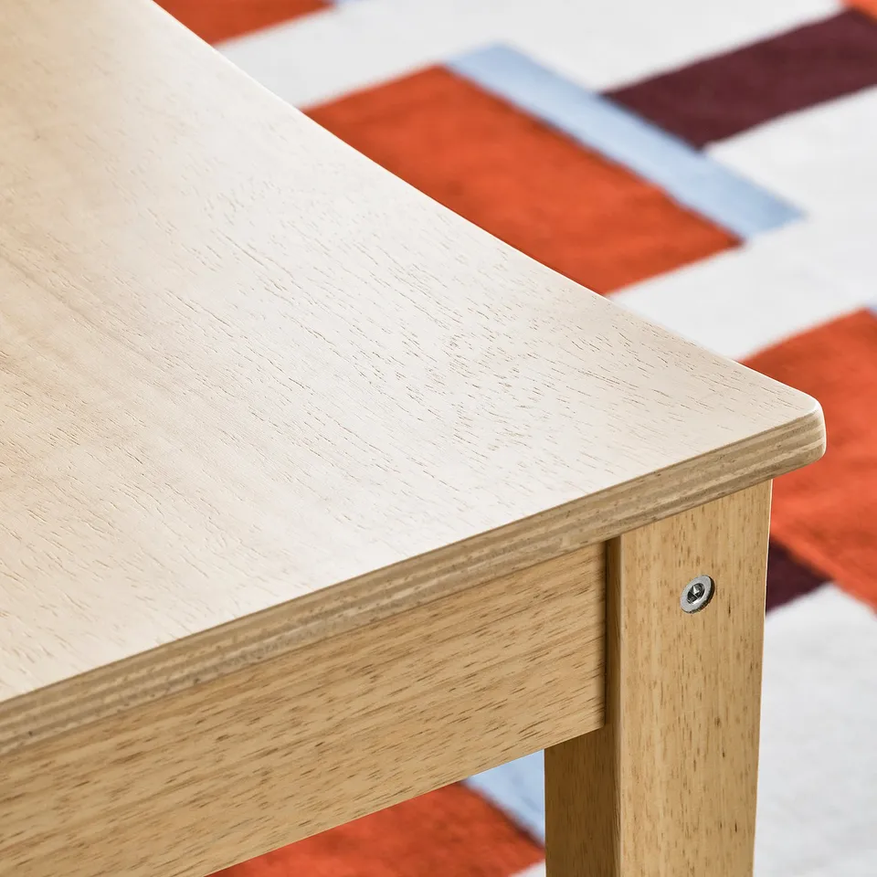 Close-up of smooth, light wooden table edge, showing quality finish and sturdy construction.