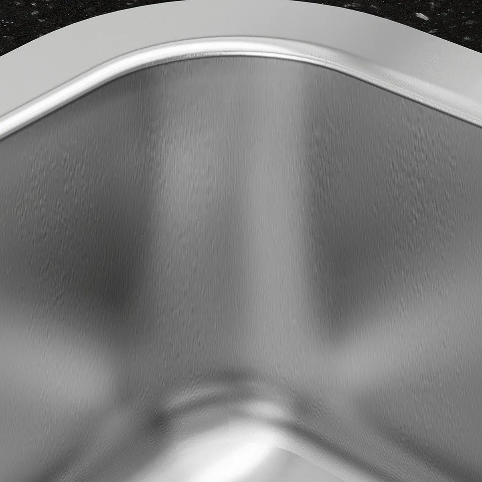 Stainless steel sink, smooth surface, curved edges, reflects light, clean design.