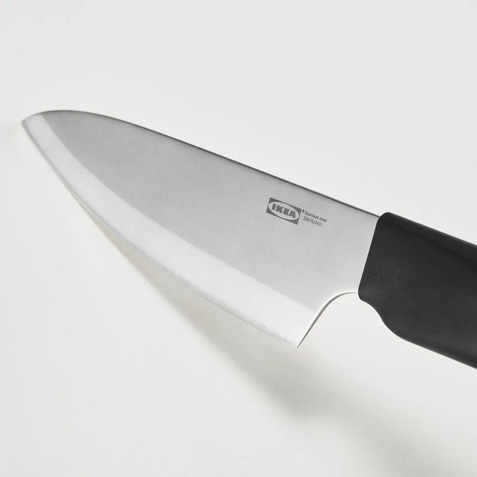 Ikea kitchen knife on white background, stainless steel blade, black handle.
