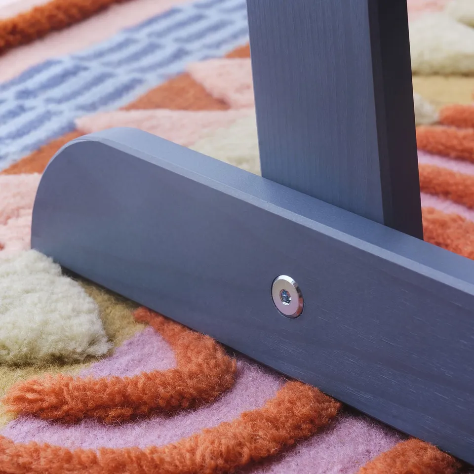 Stylish grey metal furniture leg on rug