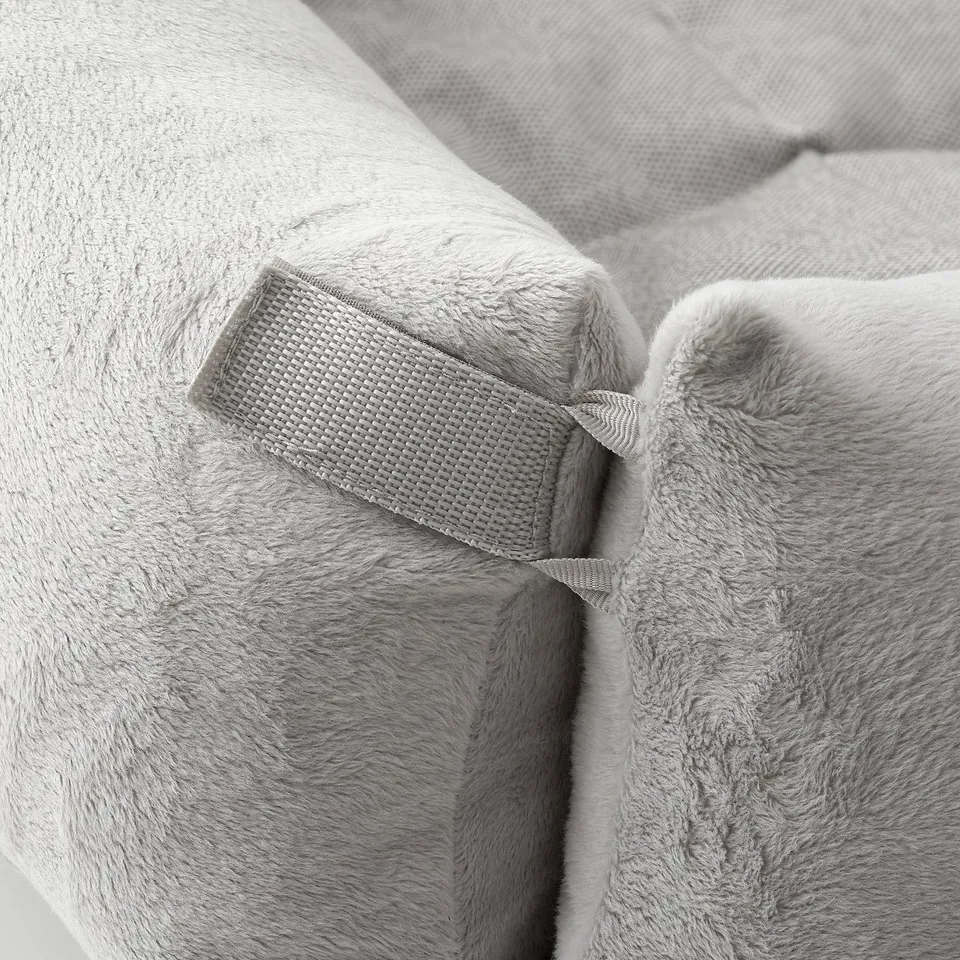 Close-up of a soft, plush dog bed with high-quality velcro fastening. Light grey texture feels comfortable and durable.