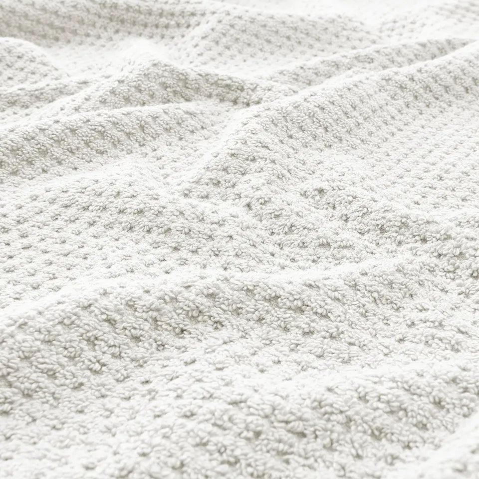 Soft, plush beige towel close-up, showcasing texture and quality.