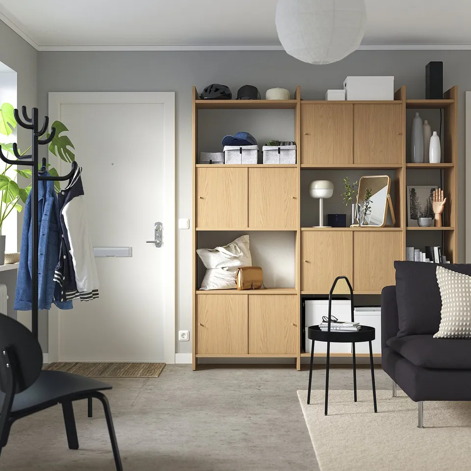 Modern living space with light wood LÅDMAKARE shelves, black furniture, and white accessories.
