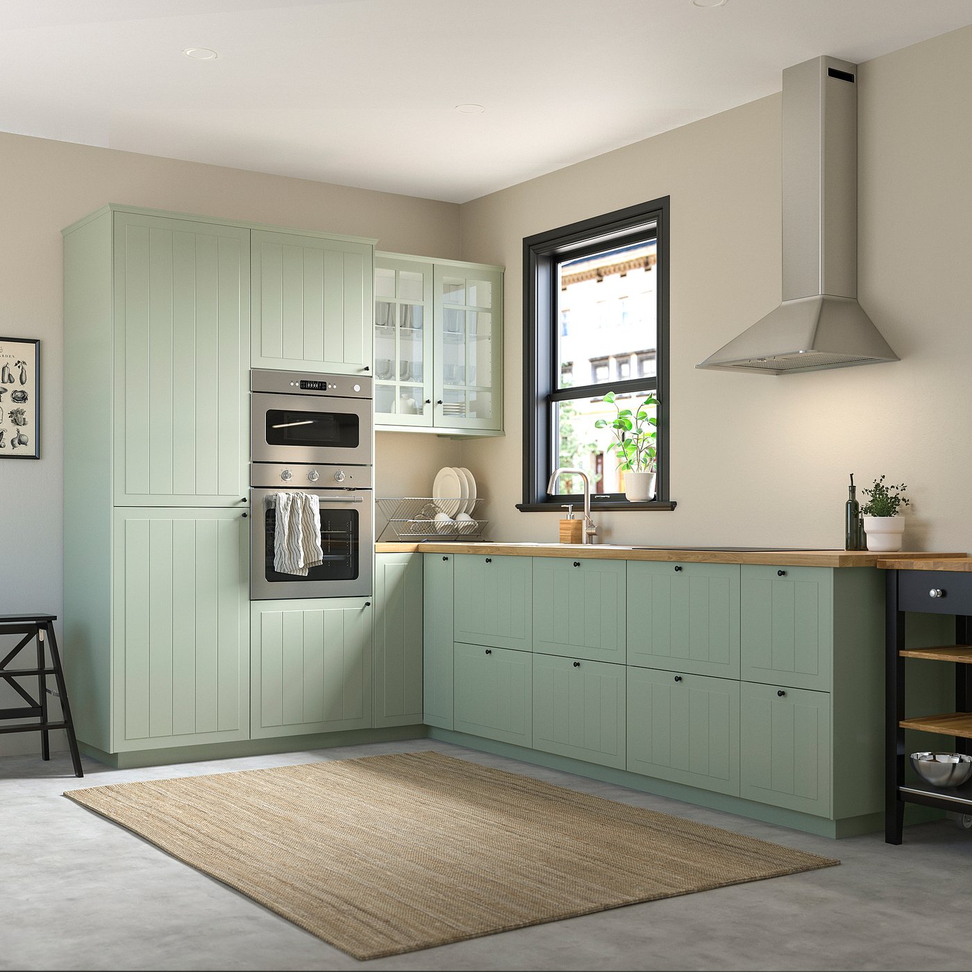 Modern kitchen with green STENSUND cabinets, wood countertops, stainless appliances, and a beige rug.