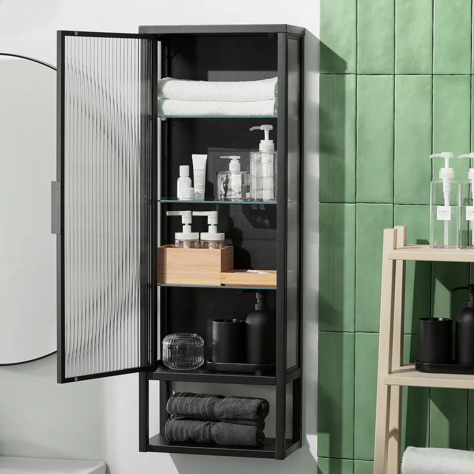 Black wall cabinet with glass shelves and a reeded glass door. The open shelf displays items, while the door hides personal items.