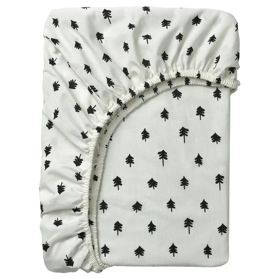 A white GRÖNFINK fitted sheet with black tree designs, made of cotton and viscose, featuring an elastic band for secure bedding.