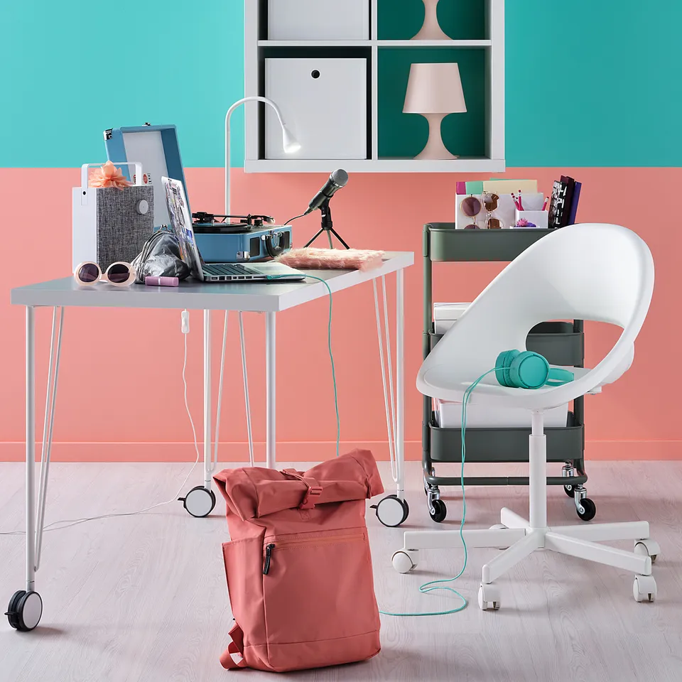 Modern home office setup with LINNMON white table, colourful accessories, and turquoise backpack.