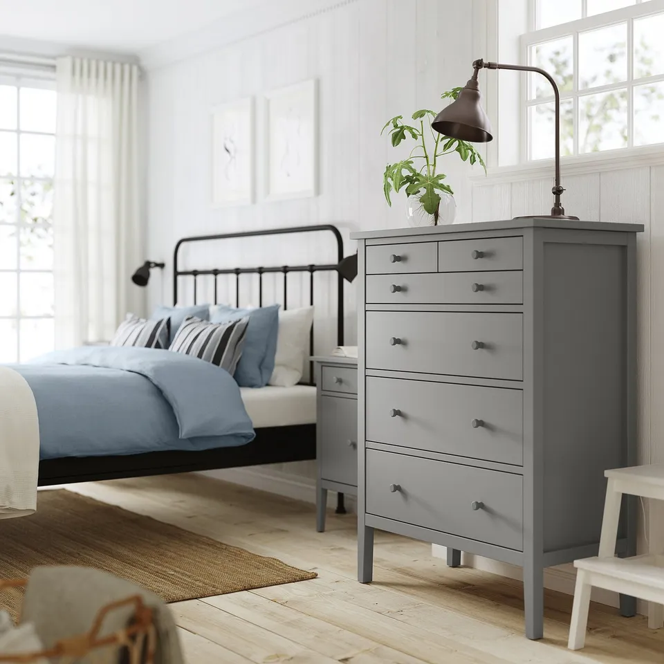 Modern bedroom with grey GULLABERG chest, metal bed, wall lamps.
