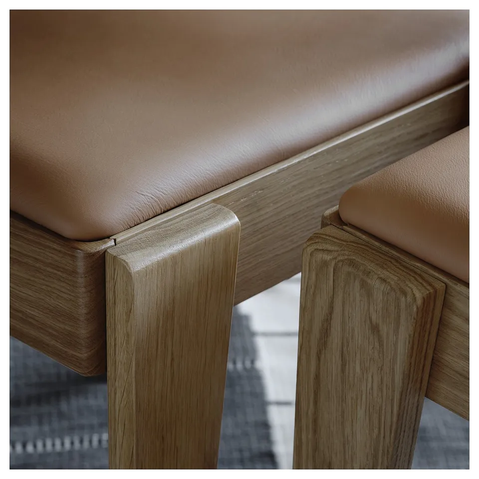Close-up of modern leather and wooden chair, showcasing high-quality craftsmanship with sleek design and durable materials.