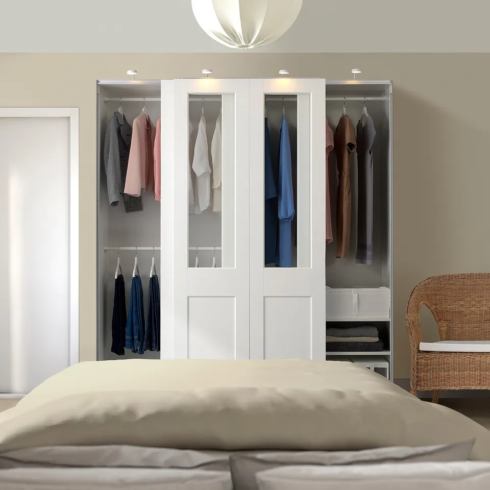 White PAX wardrobe with glass doors, displaying clothes, taller, modern sliding doors.