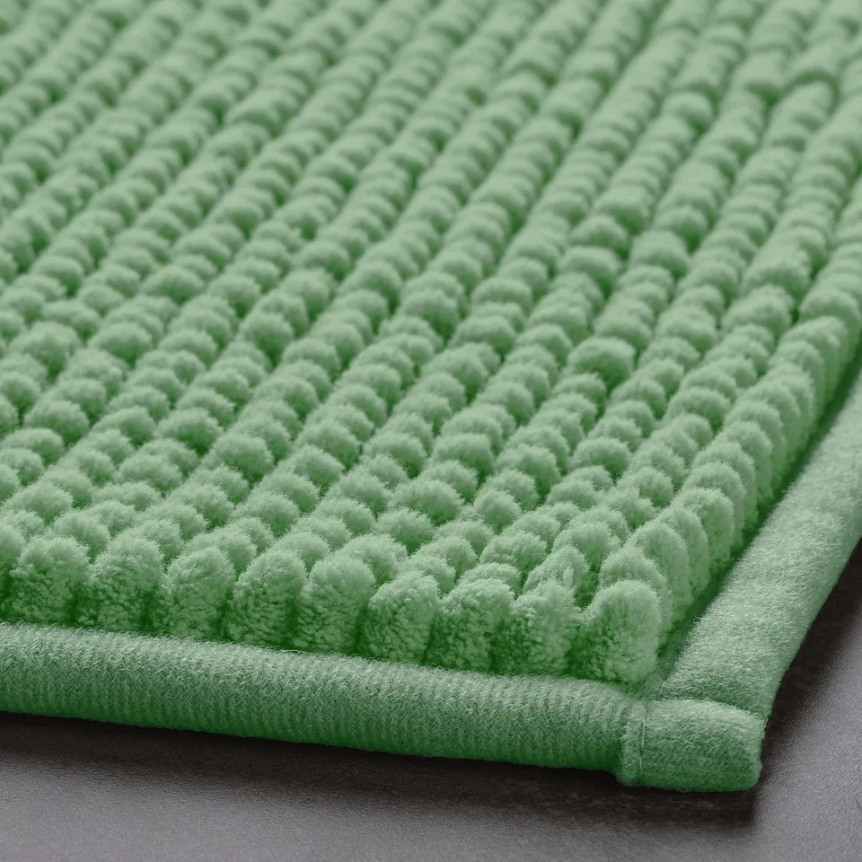 Green bath mat, ultra-soft texture, plush surface with raised dots, lightweight and quick-drying.