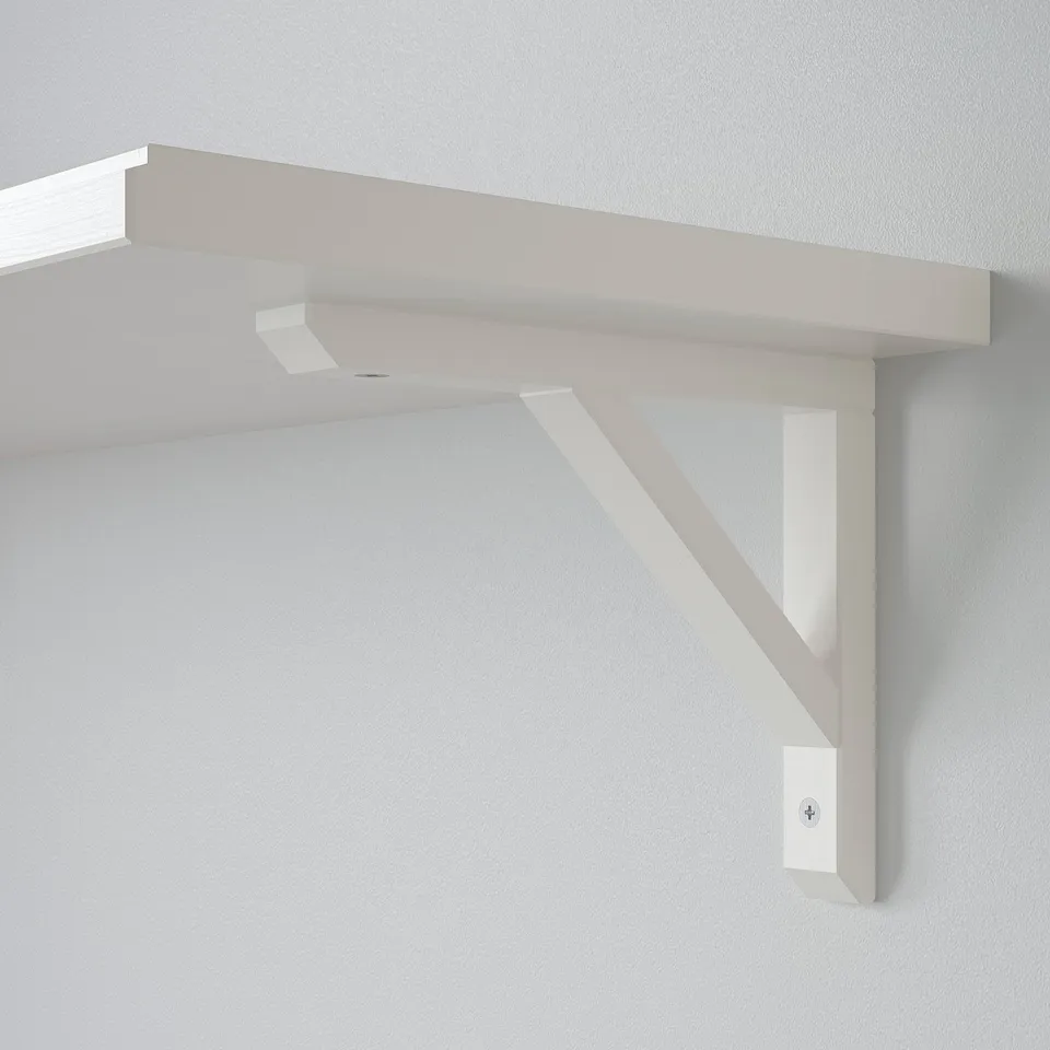 Wall-mounted white wooden shelf with angled support, clean and minimalist design.