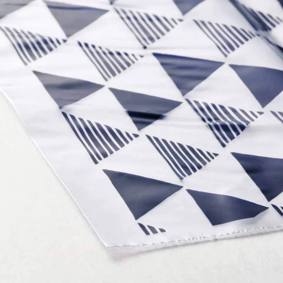 Clear, folded bags with blue geometric patterns, neatly arranged for display.