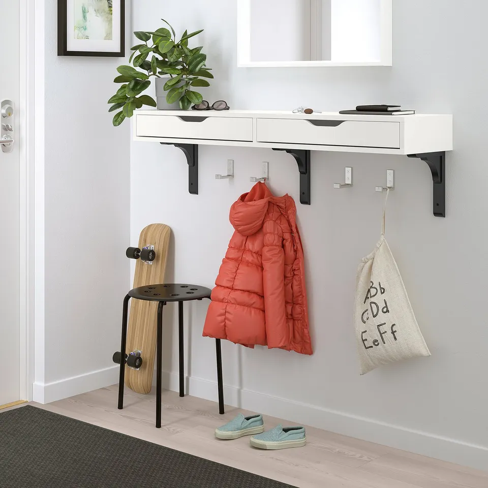 Modern hallway setup with white EKBY ALEX shelf, red puffer jacket, skateboard, and green trainers.
