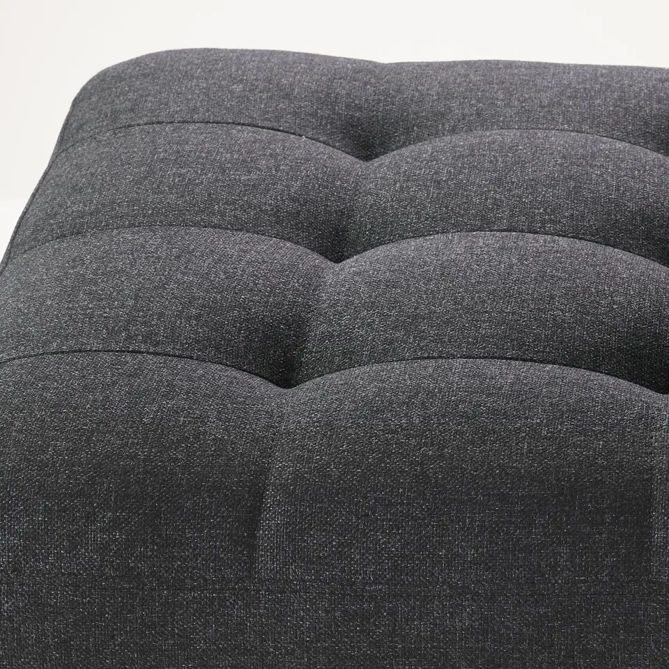 Contemporary black upholstered footstool with tufted design, showcasing high-quality fabric and elegant stitching.