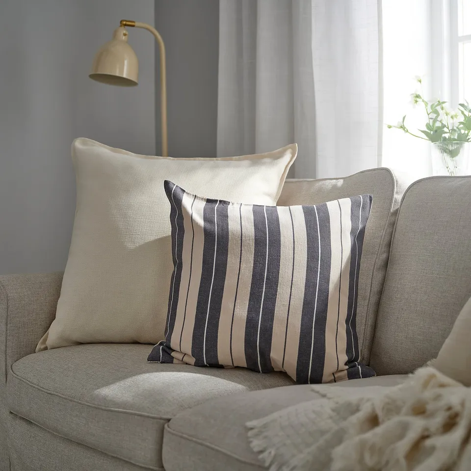 White cushion on grey couch, textured, rectangular.
