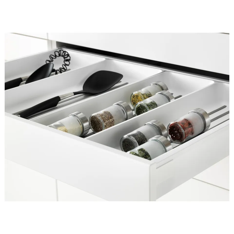 White kitchen drawer with built-in spice jars and utensils, showcasing organised storage.
