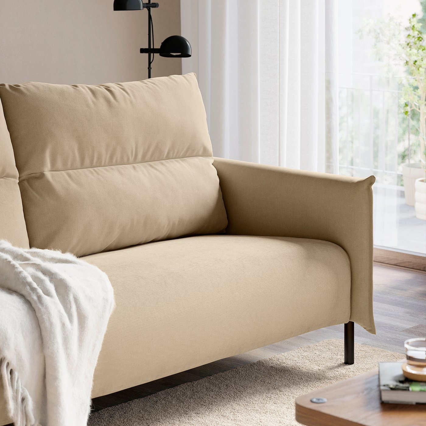 Beige armchair with cushions by window for relaxation.