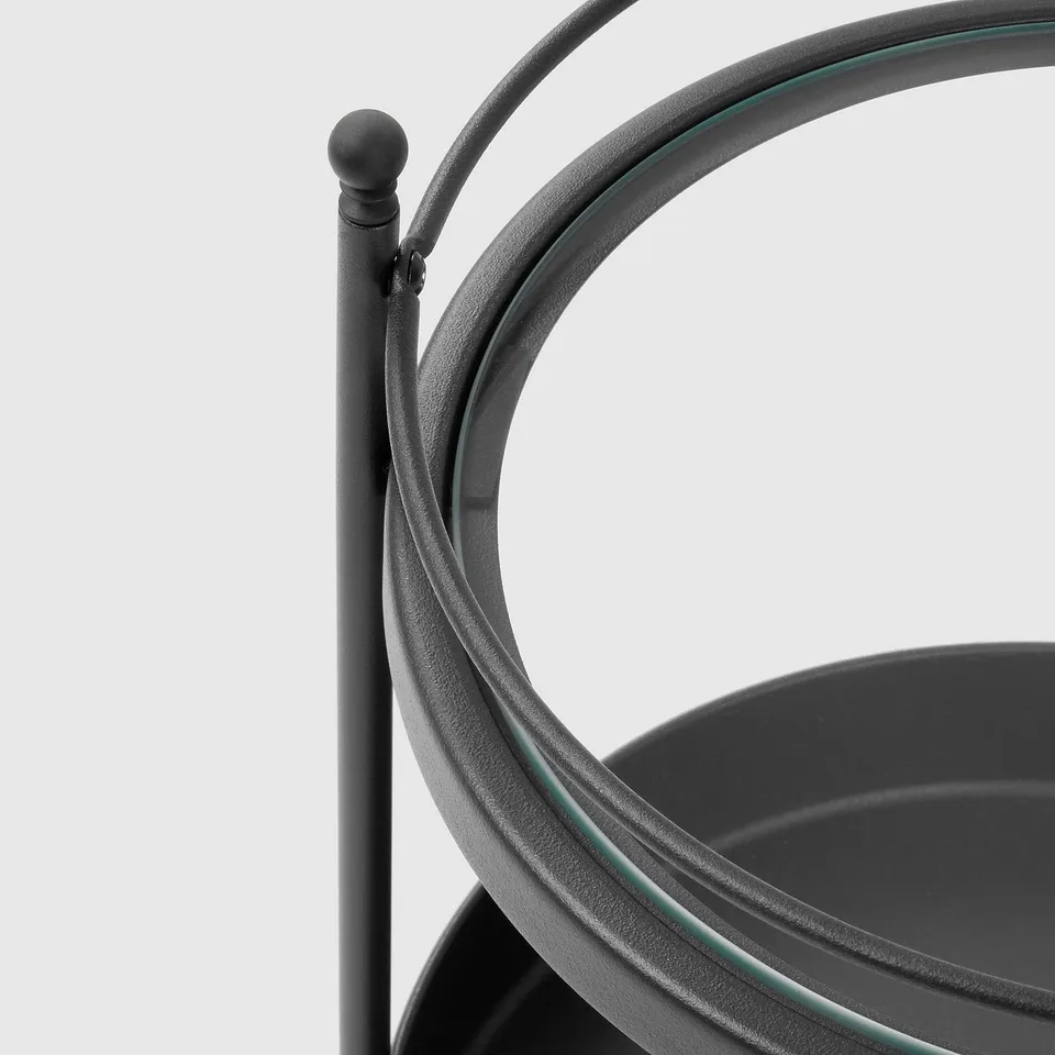 Black metal bathroom trolley with curved handle, round top, and lockable wheels. Modern design for easy mobility and storage.