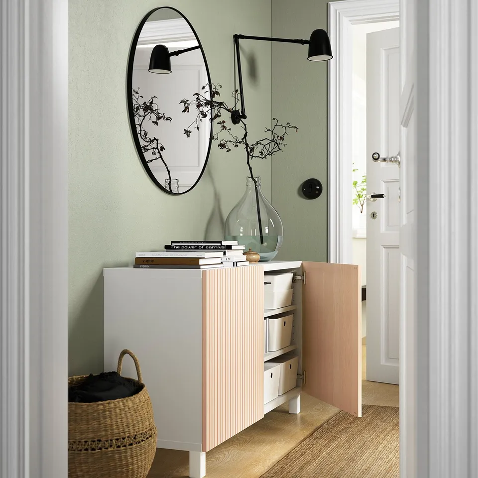 Modern entryway with BESTÅ sideboard, mirror, wall lamps, and basket.