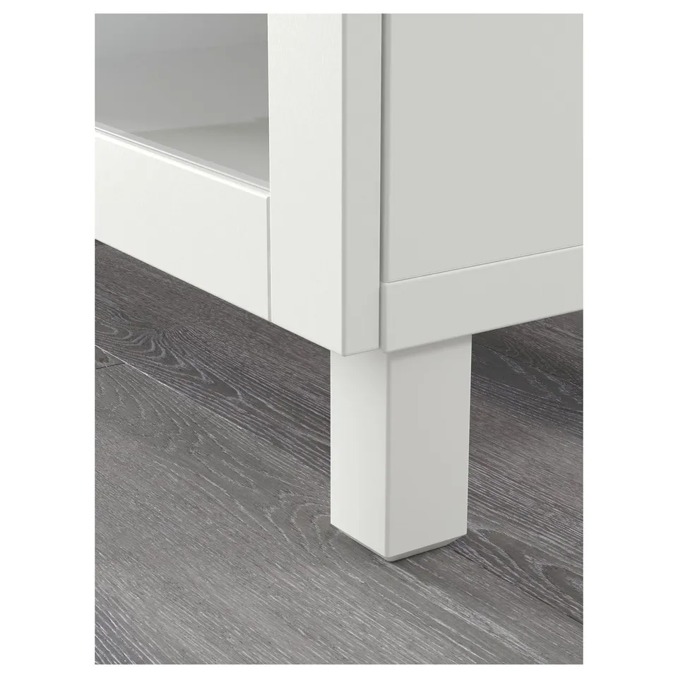 Modern white cabinet with simple, clean design on wooden floor.