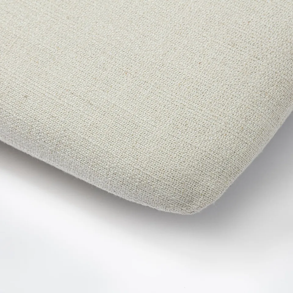 Close-up of a beige woven cushion, showcasing its smooth texture and even stitching.