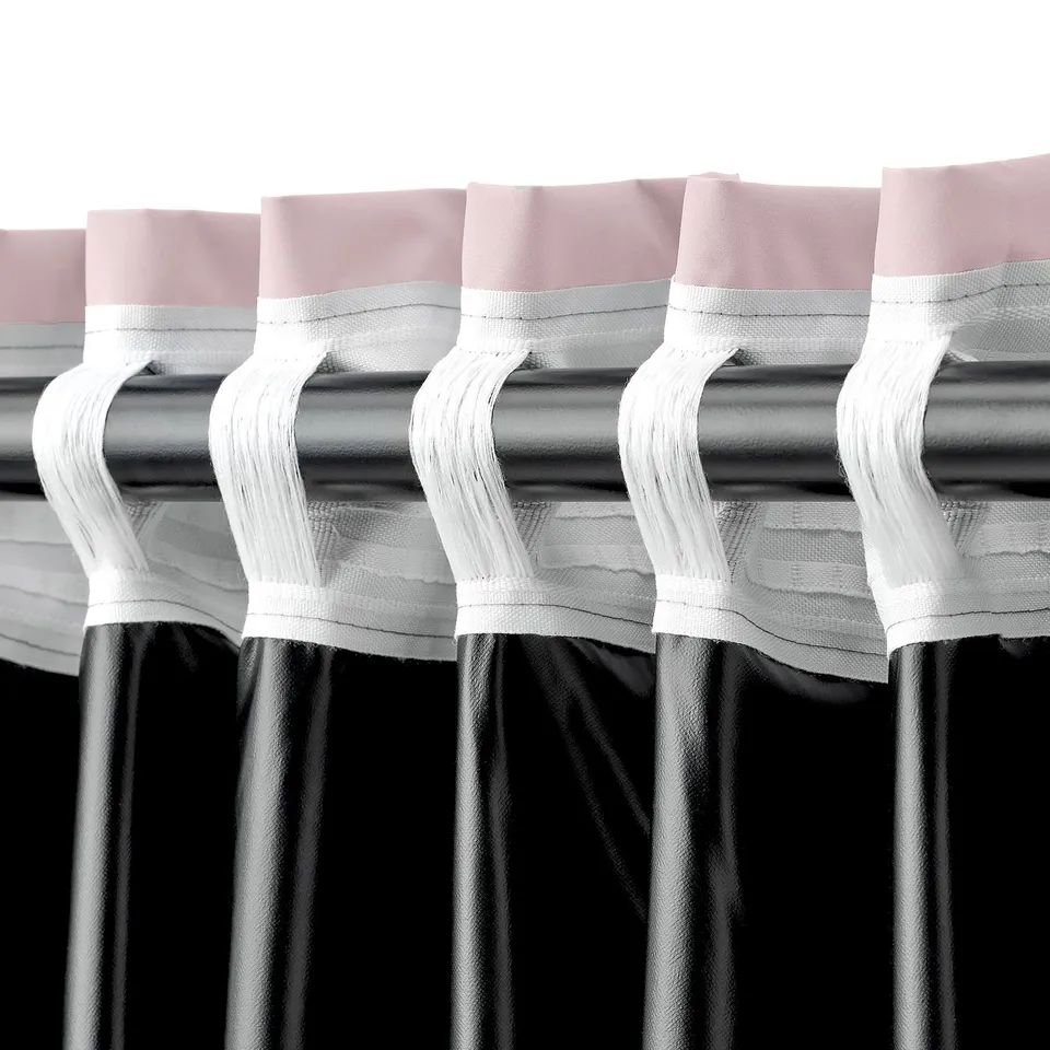 Blackout curtains with pink and white tabs hang neatly, blocking light and offering easy rod-pocket hanging.