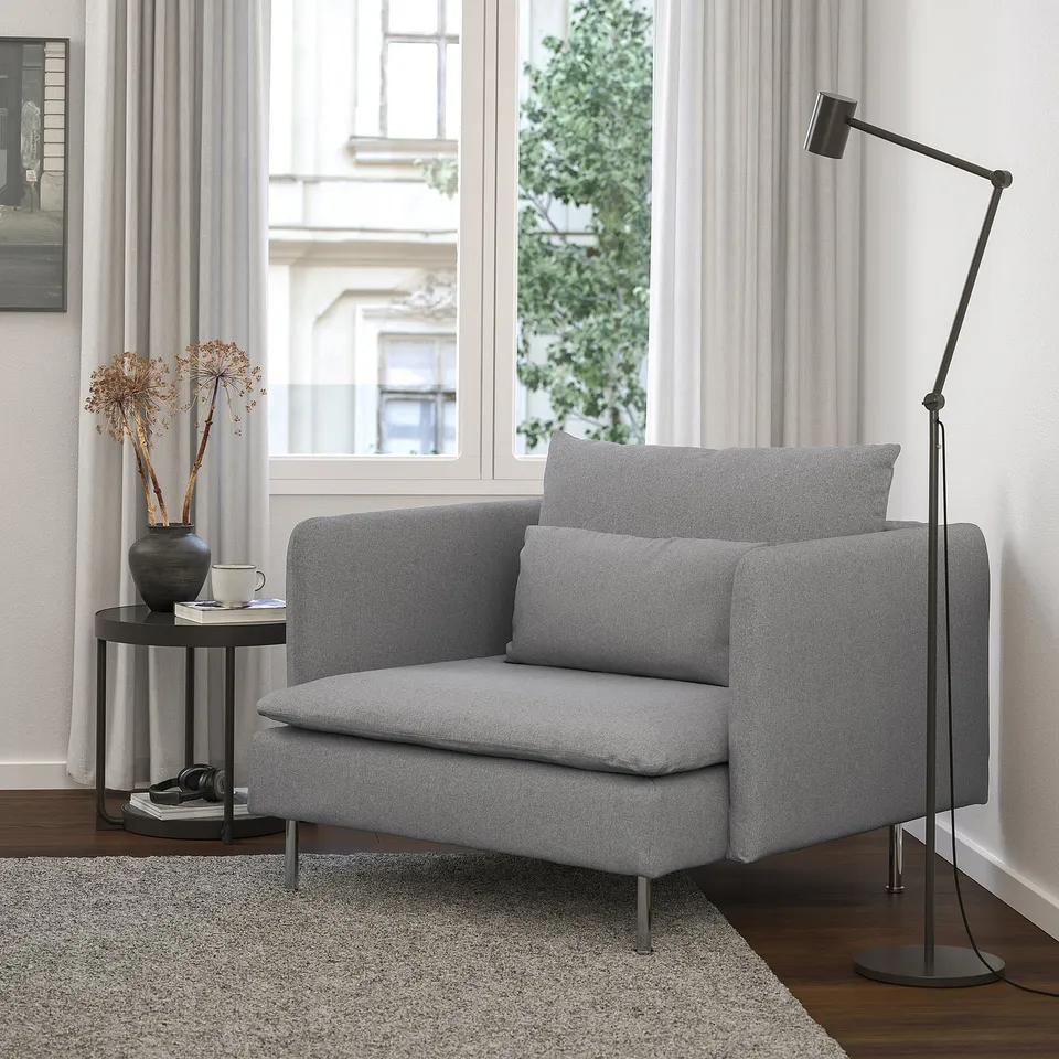 Modern grey SÖDERHAMN chair in cosy room, wooden floor, black floor lamp, side table with vase.