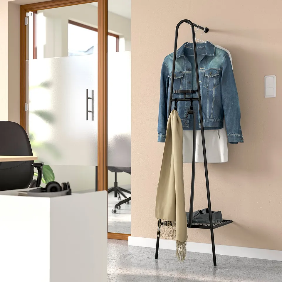 ÄLGANÄS black metal wall clothes rack with tan jacket and scarf, slim design fits narrow spaces.