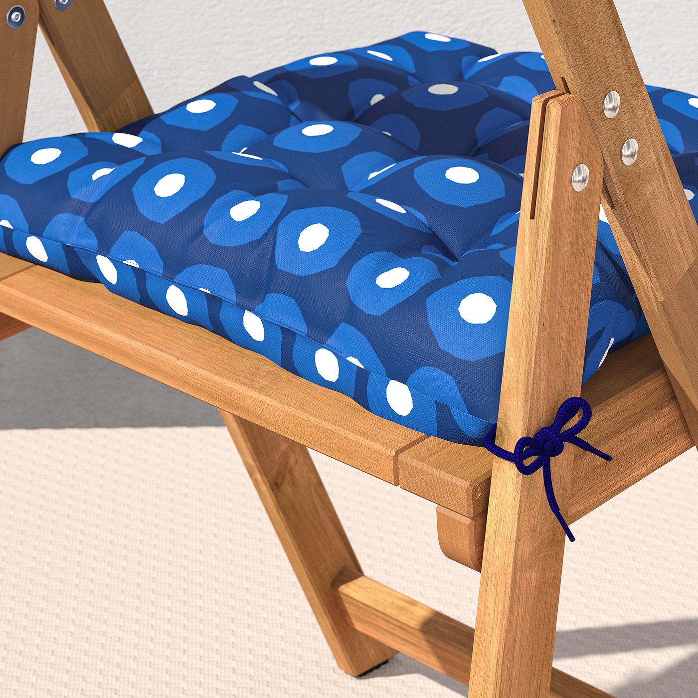 Wooden folding chair with secure, patterned cushion tied in place, made of recycled polyester.